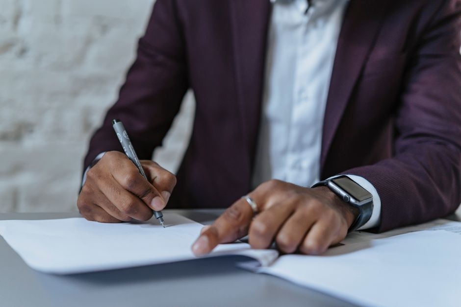 Gros plan sur un homme signant des documents dans un bureau. Environnement professionnel axé sur les affaires.
